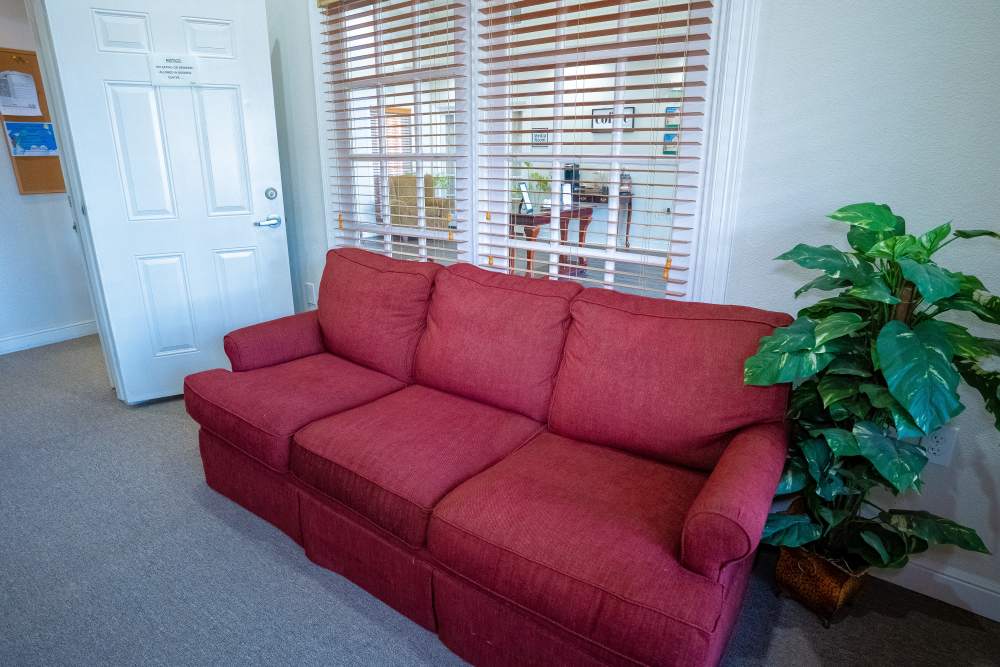 Red color sofa in business center at Timber Village in Marshall, Texas
