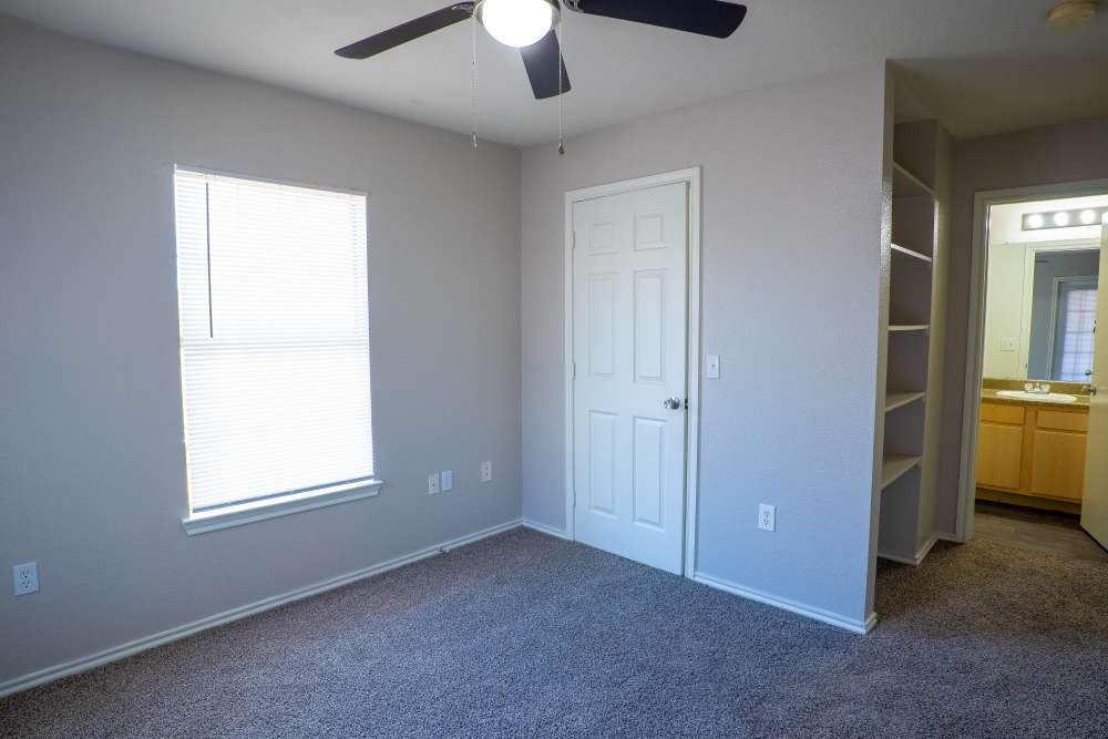 Bedroom with ceiling fan and window at Timber Village in Marshall, Texas