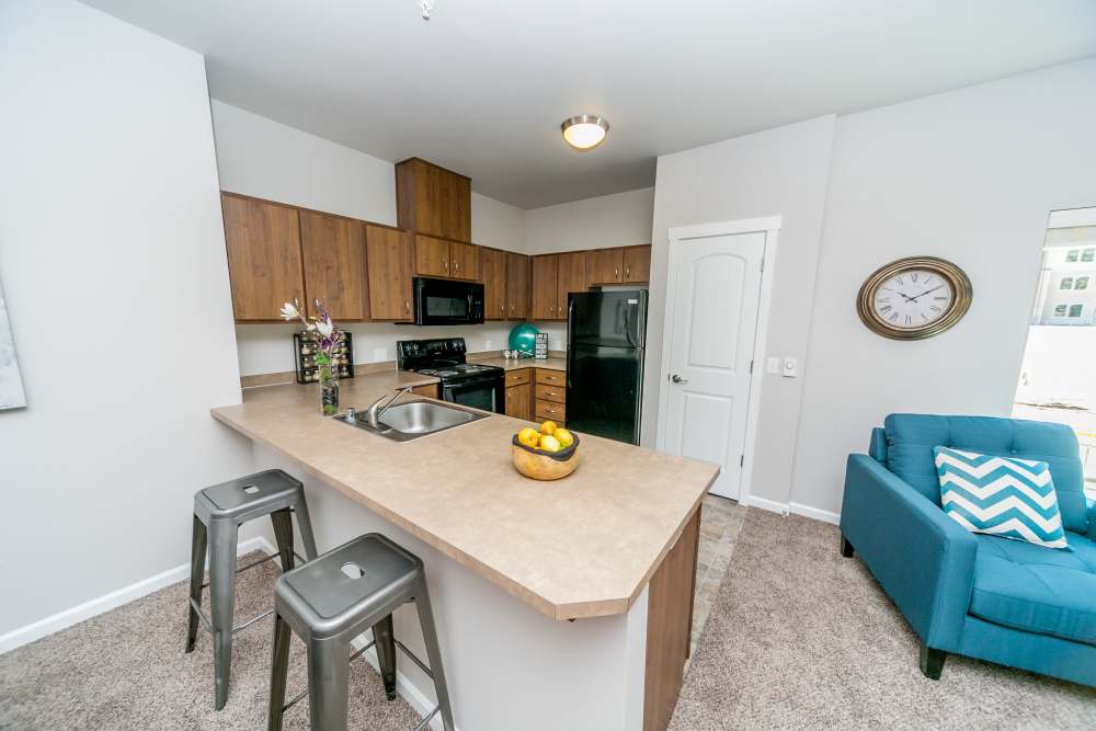 Kitchen with wood cabinets, island seating, and modern appliances at Columbia View in Vancouver, Washington