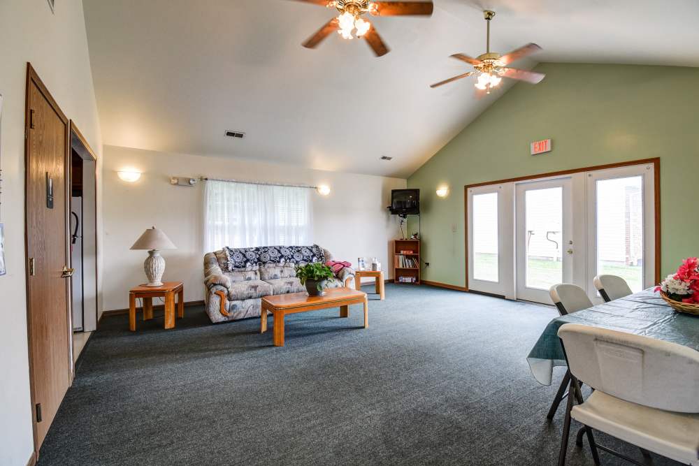 Bright community room with cozy seating, large windows, and dining area for gatherings at Catawba Club in Berkeley Springs, West Virginia