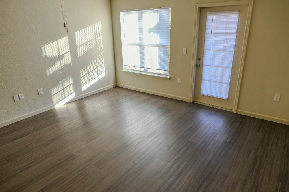 Unfurnished living room with wood-style flooring and large window at Tupelo Ridge in Warner Robins, Georgia
