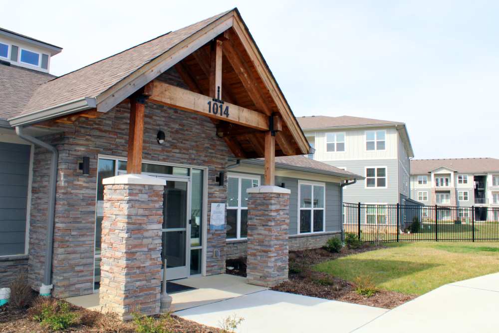Gated entrance with stone pillars and wooden awning leading to apartment community at Jefferson's Landing in Louisville, Kentucky