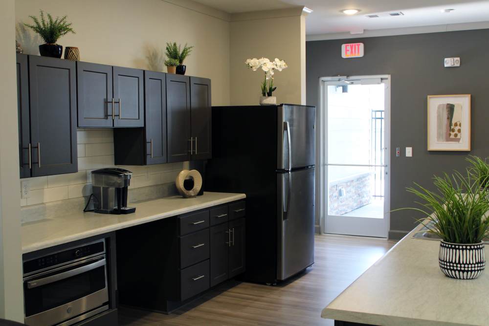 Modern kitchen with granite countertops, stainless steel appliances, and wood-style flooring at Jefferson's Landing in Louisville, Kentucky