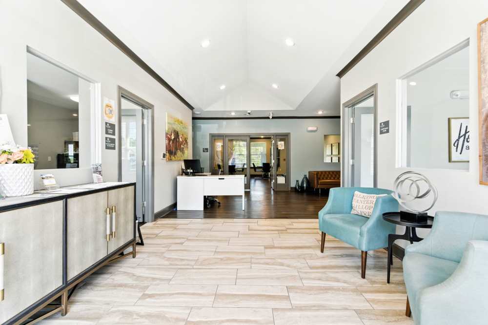 Bright, welcoming lobby with modern decor, wood-style flooring, and comfortable seating areas at Bristol Bluffs Apartments in Louisville, Kentucky