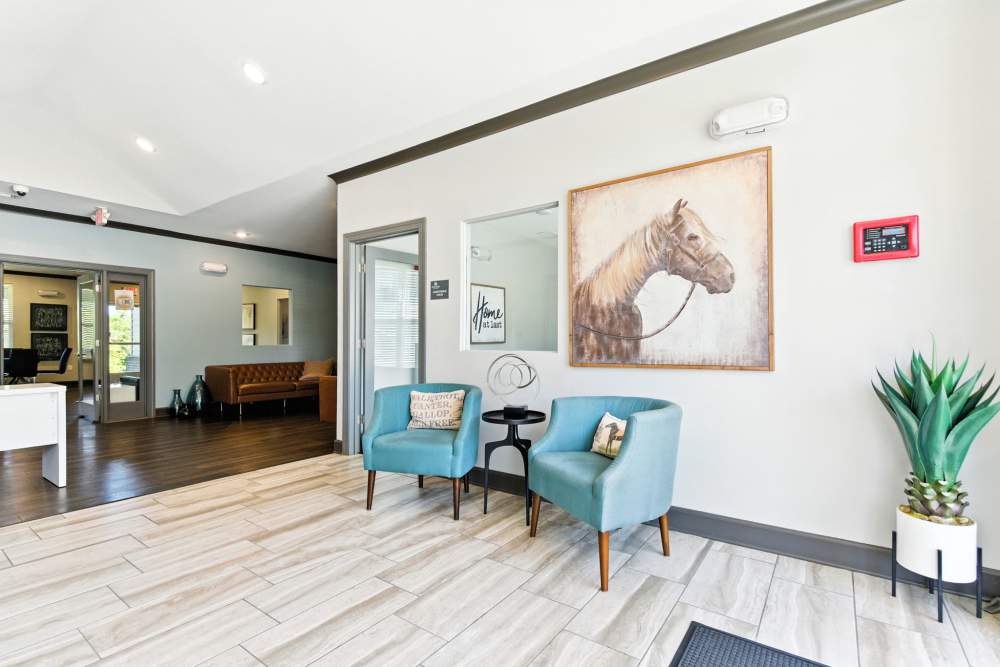 Bright lobby with modern seating, artwork, and wood-style flooring, welcoming atmosphere for residents and guests at Bristol Bluffs Apartments in Louisville, Kentucky