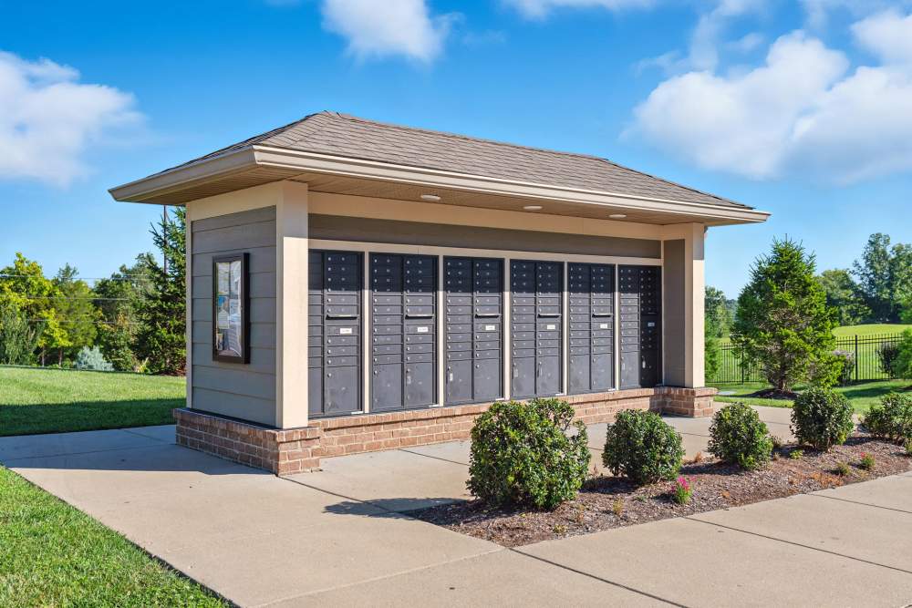 Gated mailbox area with landscaped shrubs and clear blue sky in the background at Bristol Bluffs Apartments in Louisville, Kentucky