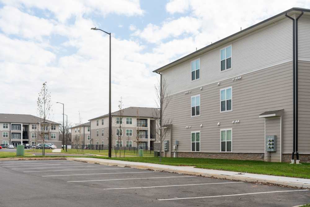 Exterior of modern apartment buildings with ample parking at Lone Oak Meadows in Louisville, Kentucky