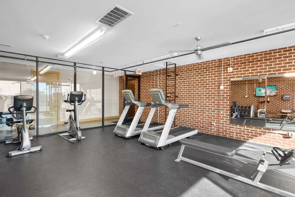 Modern fitness center with treadmills, stationary bikes, and large mirrors at Ingersoll Square in Des Moines, Iowa