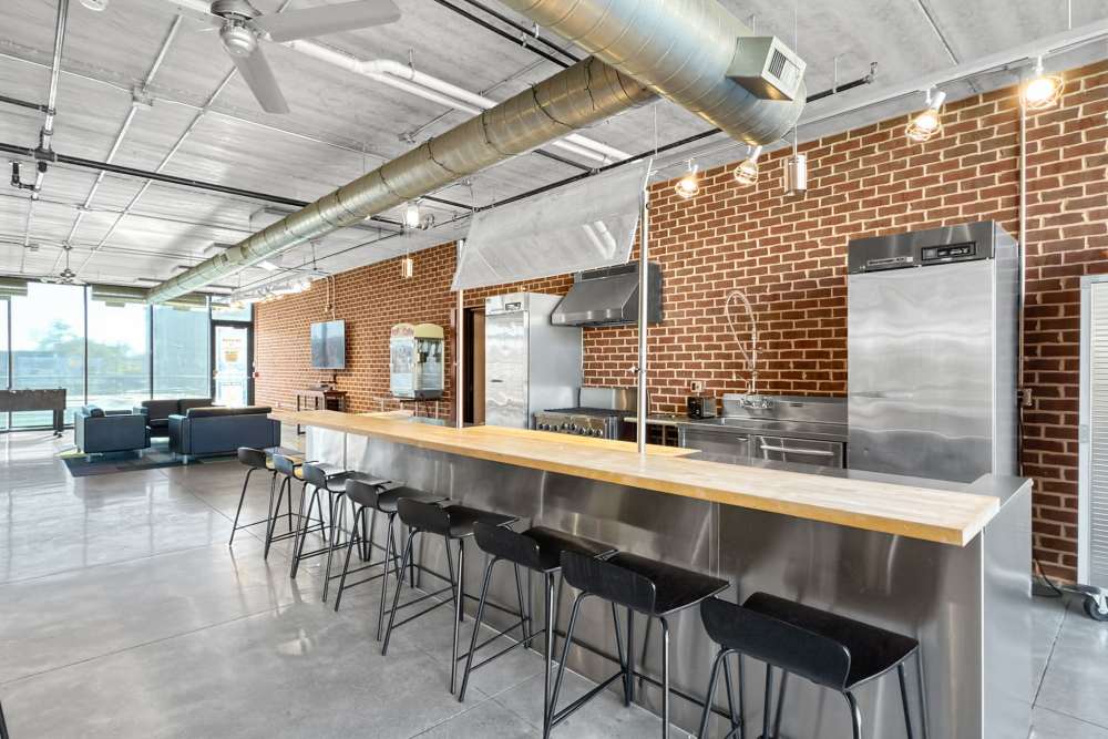 Modern kitchen with stainless steel appliances, bar seating, and open layout in a stylish community space at Ingersoll Square in Des Moines, Iowa