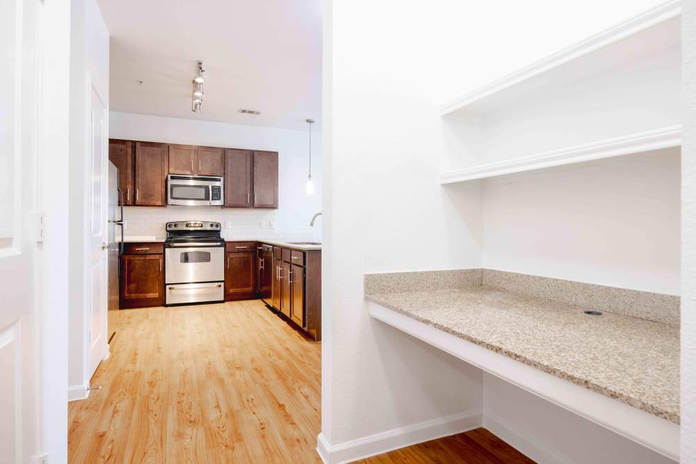Modern apartment in Austin, Texas with a built-in desk and kitchen equipped with stainless steel appliances and contemporary cabinets.