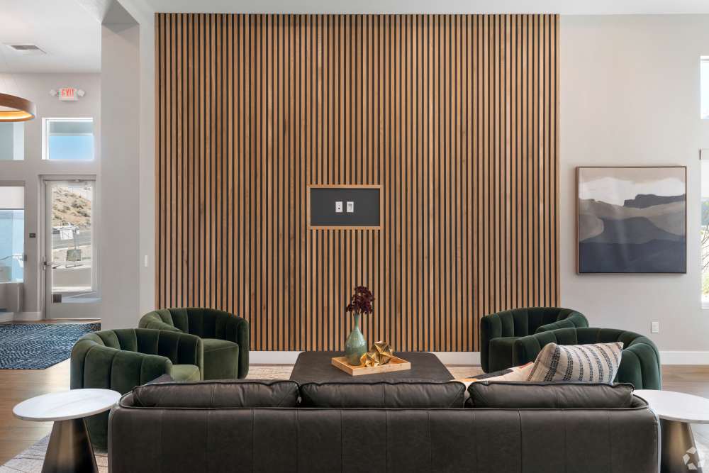 Lounge seating area with green chairs facing a wood slat accent wall at Sage by Vintage in Reno, Nevada
