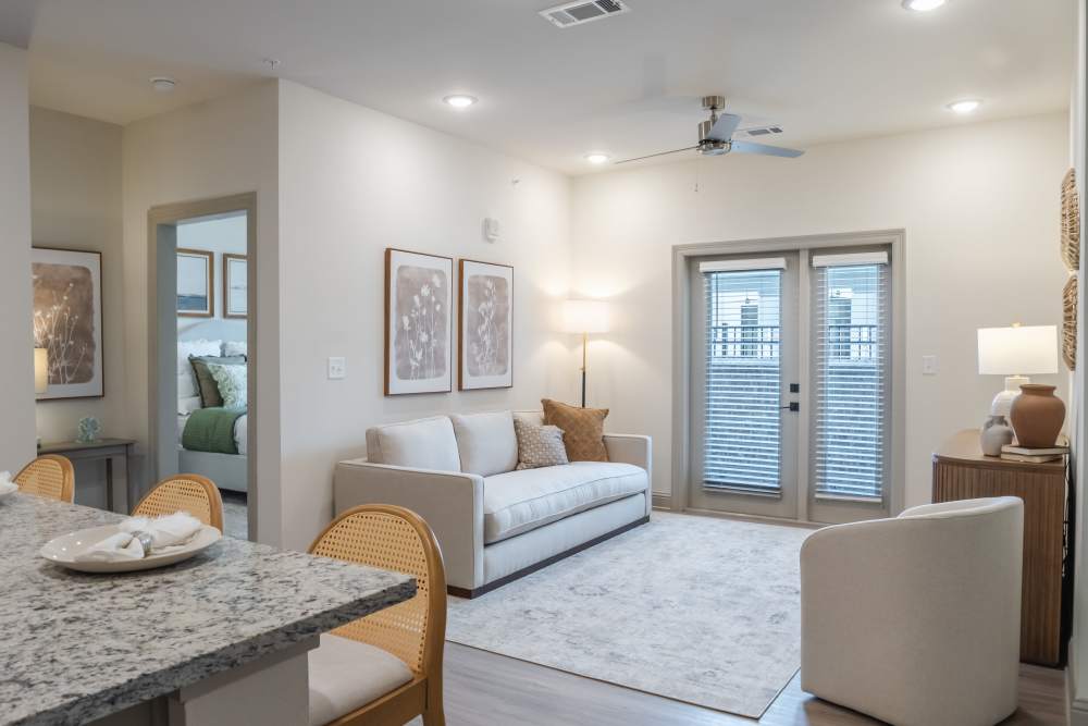 Bright living room with ceiling fan and carpeted flooring at The Heights at Waterpointe in Flowood, Mississippi