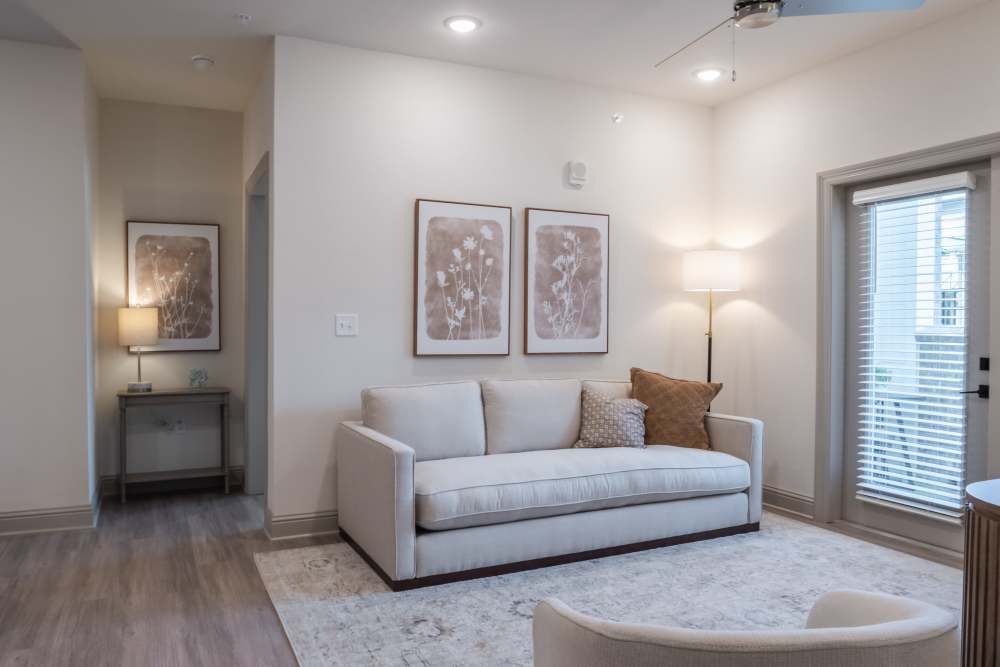 White couch and standing lamp in the living room at The Heights at Waterpointe in Flowood, Mississippi