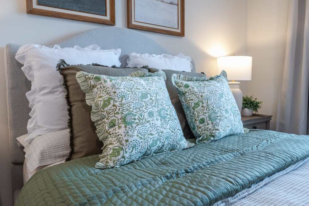 Bed with colorful sheets and pillowcases at The Heights at Waterpointe in Flowood, Mississippi