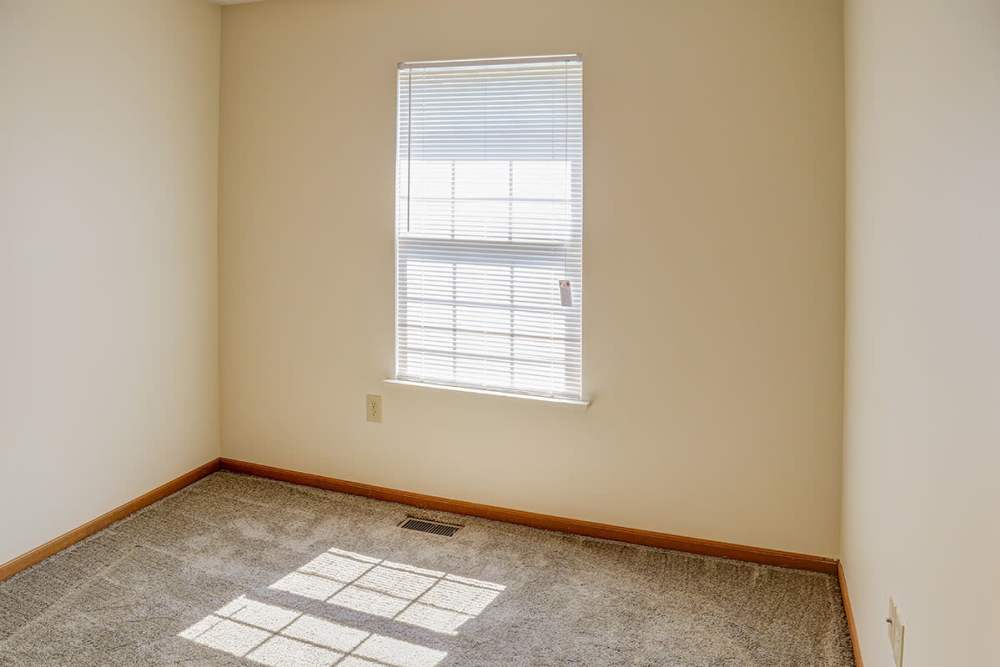 Empty room with carpet flooring and a window allowing natural light at Arlington Greene in London, Kentucky