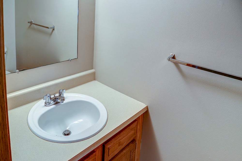 Bathroom with a single sink, wooden cabinetry, and a large mirror at Arlington Terrace in London, Kentucky