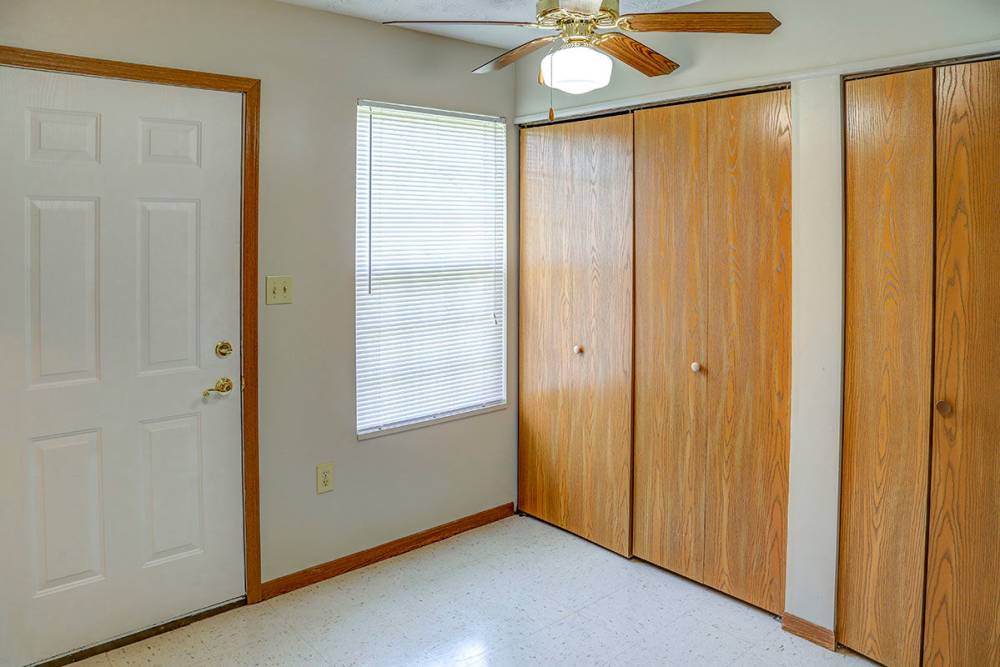 Bright entryway with a ceiling fan, closet doors, and a window with blinds at Arlington Terrace in London, Kentucky