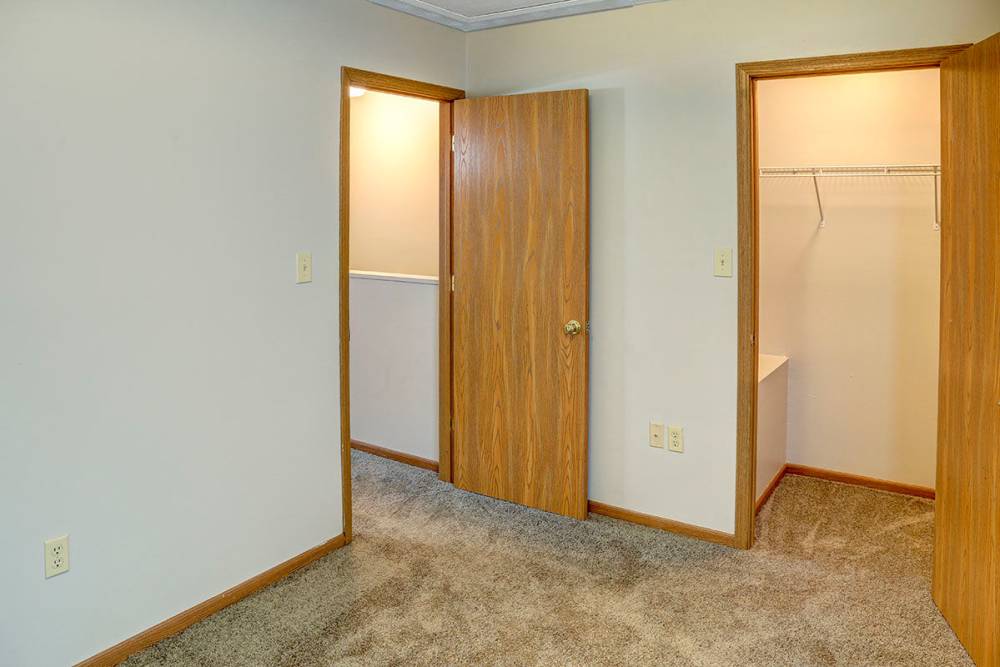 Cozy bedroom with carpeted flooring, two doors leading to closet and bathroom at Arlington Terrace in London, Kentucky