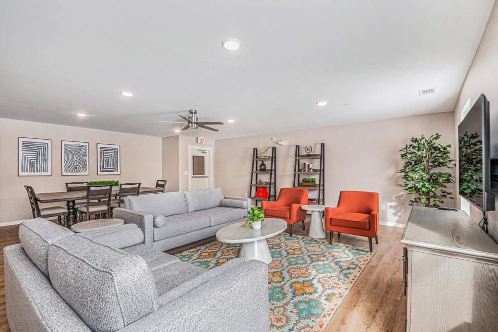 Bright living area with wood-style flooring, comfortable seating, and dining table for gatherings at Breton Grove II in Grand Rapids, Michigan
