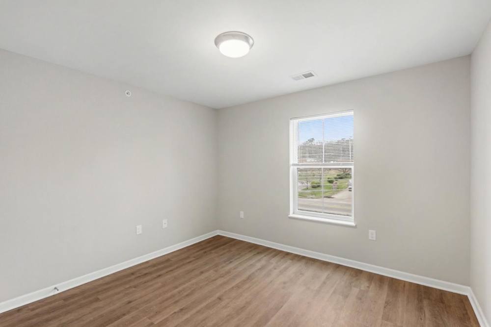 Bright room with wood-style flooring and large window offering natural light at Bridlewood Crossing in Louisville, Kentucky