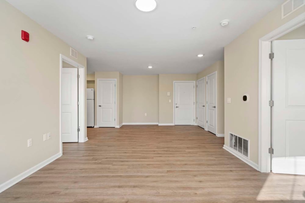 Spacious open layout with wood-style flooring and multiple doors leading to rooms at Edison Crossing in Mount Clemens, Michigan