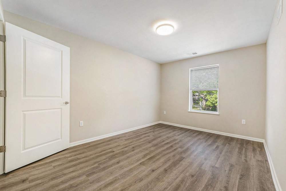 Spacious bedroom with wood-style flooring and natural light from window at Annika Place in Traverse City, Michigan