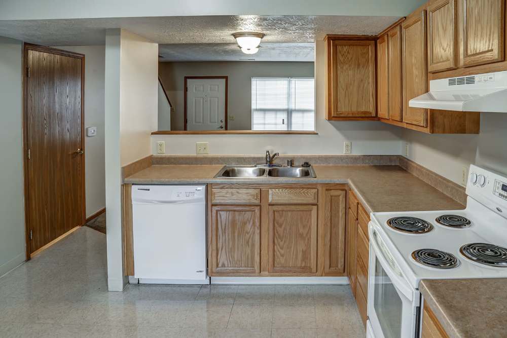 Bright kitchen with wood-style cabinets, stainless steel appliances, and open layout inviting natural light at Paint Lick Station in Stambaugh, Kentucky