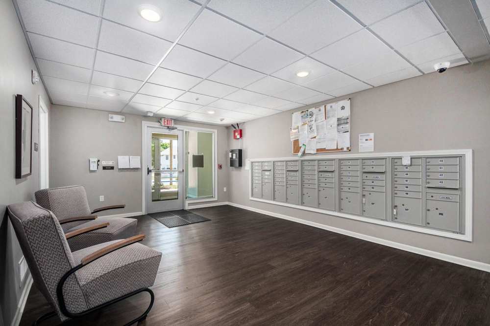 Bright lobby with mailboxes, modern seating, and wood-style flooring, welcoming atmosphere for residents at Seven45 Stocking in Grand Rapids, Michigan