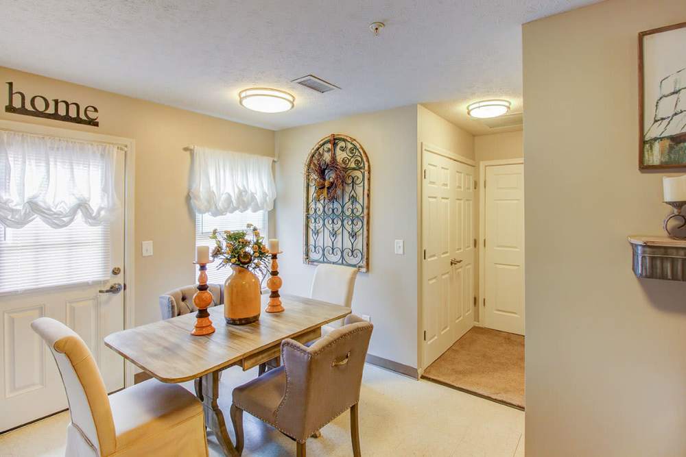 Bright dining area with a wooden table, upholstered chairs, and decorative wall art at Pennington Crossing in Johnson City, Tennessee