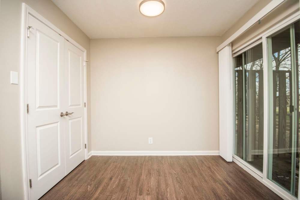Empty room with wood-style flooring and sliding glass door leading to outdoor space at Plainsview Greene in Tellico Plains, Tennessee