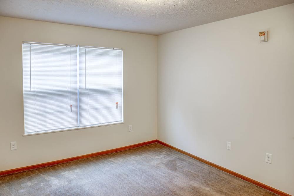 Empty room with beige carpet, two windows with blinds, and light-colored walls at Preston's Crossing in Prestonsburg, Kentucky
