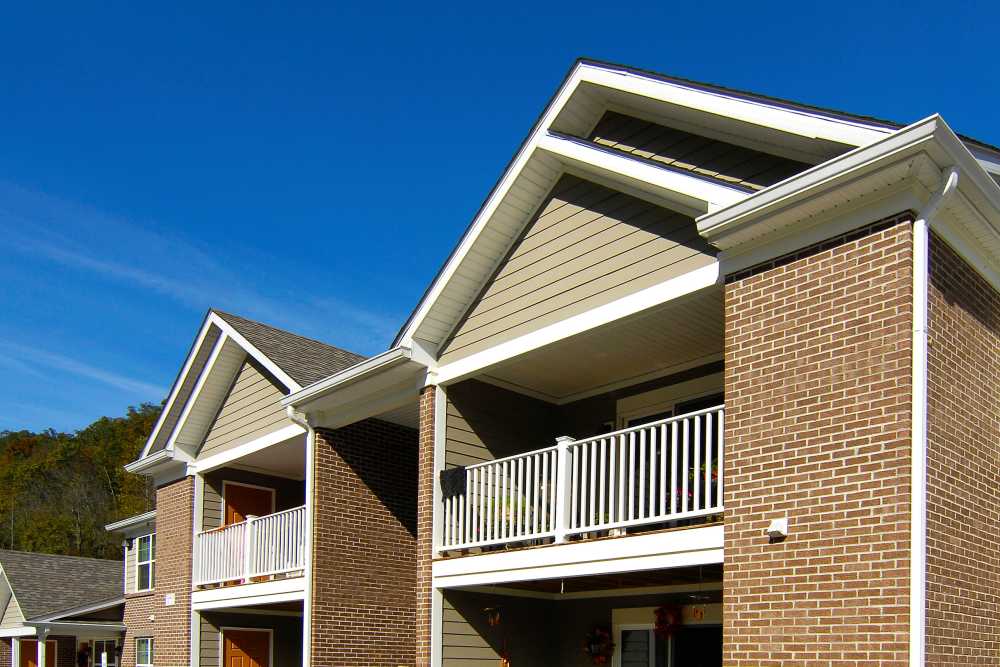 Two-story apartment building with balconies and brick exterior under a clear blue sky at Preston's Crossing in Prestonsburg, Kentucky