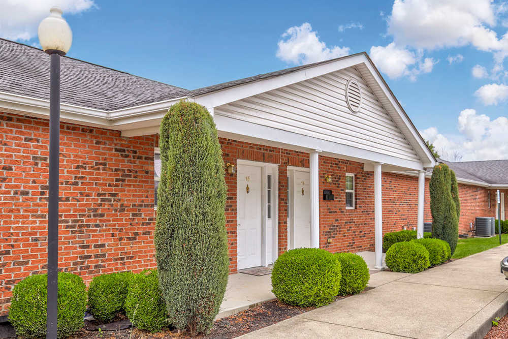 Gated entrance with manicured shrubs and brick exterior, inviting atmosphere and well-maintained landscaping at Sawgrass Greene in Grayson, Kentucky