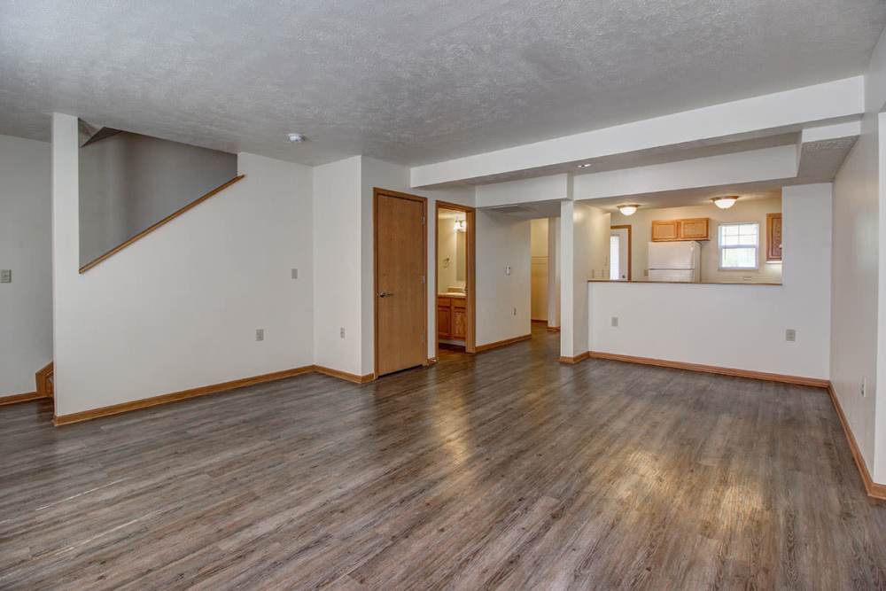 Spacious open layout with wood-style flooring and access to kitchen area at Sterling Greene in Fayetteville, Tennessee
