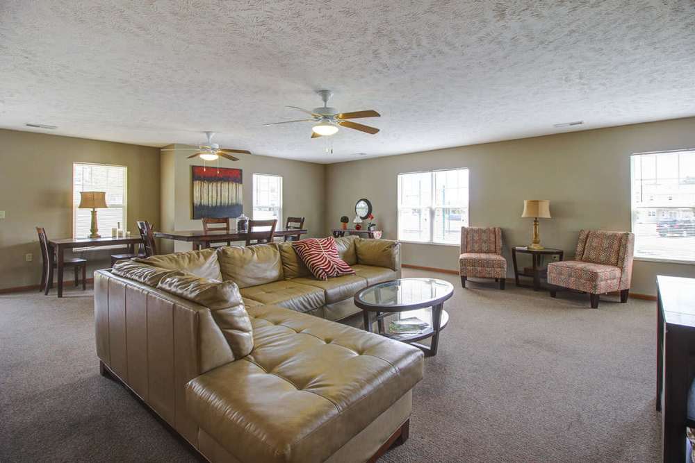Spacious living area with plush seating, dining table, and natural light from large windows at Sterling Greene in Fayetteville, Tennessee