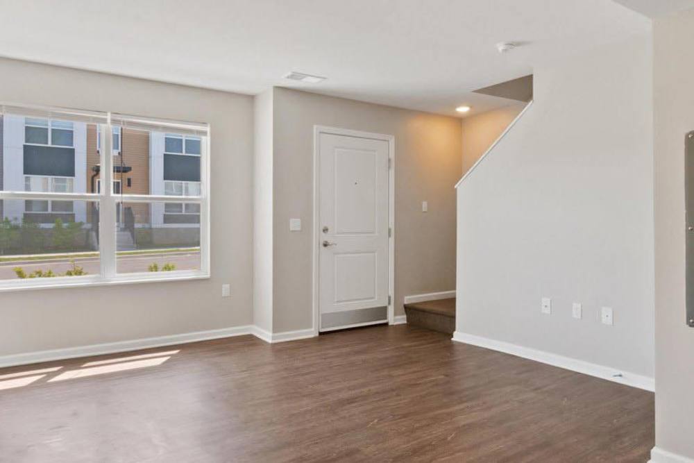 Bright living area with wood-style flooring and large windows, inviting natural light indoors at Winston Commons in Pontiac, Michigan