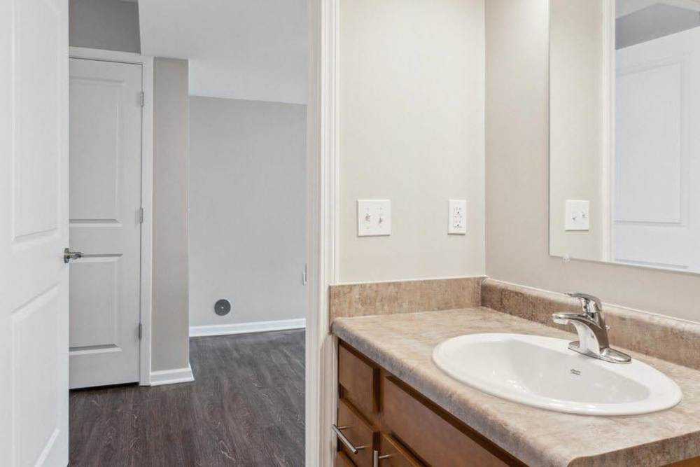 Modern bathroom with wood-style flooring, single sink vanity, and neutral wall colors at Winston Commons in Pontiac, Michigan