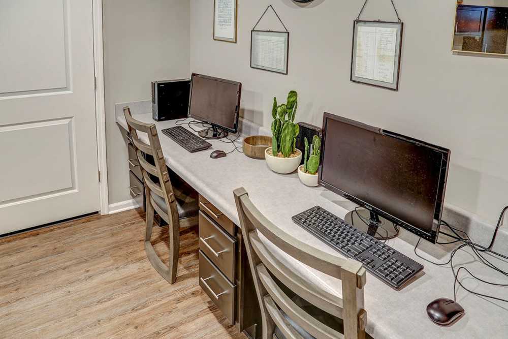 Home office area with two computers, modern chairs, and potted plants on a countertop at Tristan Ridge in Eminence, Kentucky