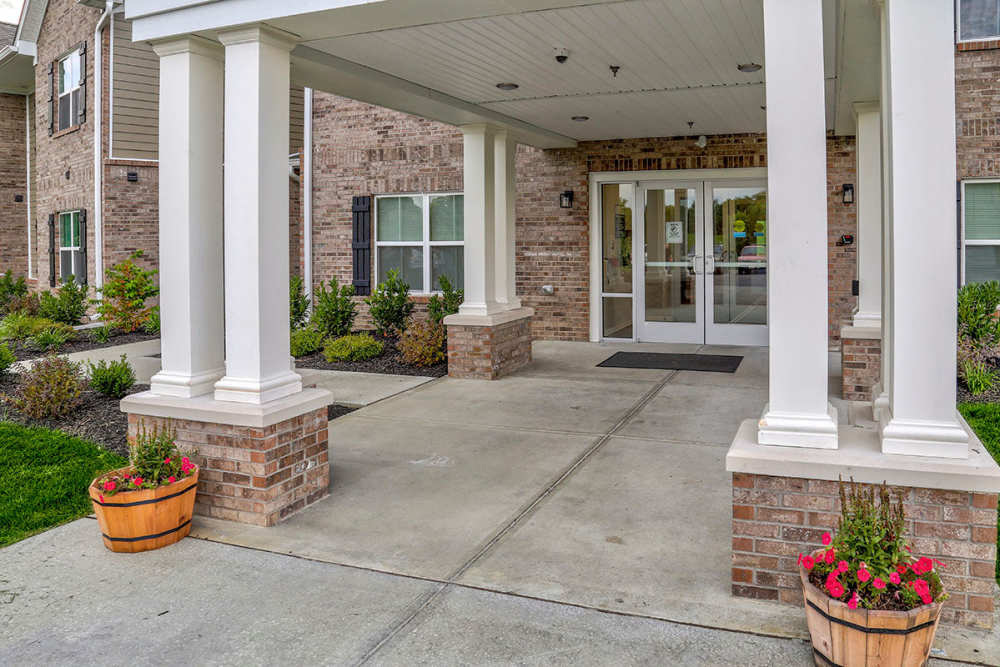 Welcoming entrance with potted flowers and covered porch, surrounded by landscaped greenery at Tristan Ridge in Eminence, Kentucky