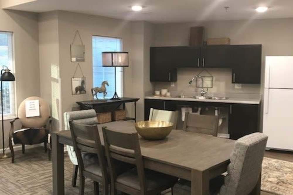 Open layout kitchen with stainless steel appliances and dining area featuring a wooden table and stylish chairs at Tristan Ridge in Eminence, Kentucky