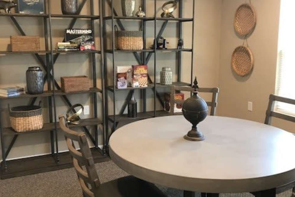 Modern dining area with round table, stylish chairs, and decorative shelving units at Tristan Ridge in Eminence, Kentucky