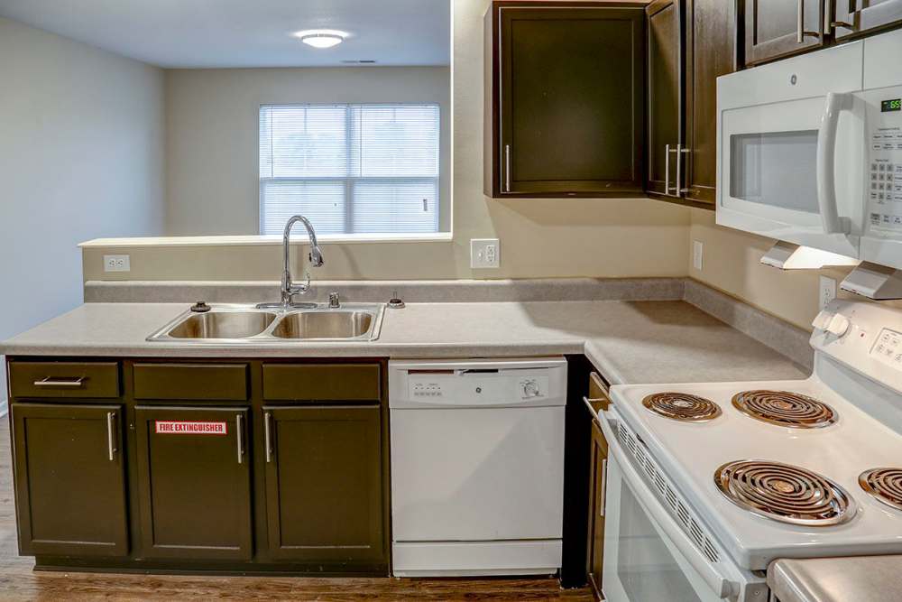 Modern kitchen with granite countertops, stainless steel appliances, and dark cabinetry at Tristan Ridge in Eminence, Kentucky