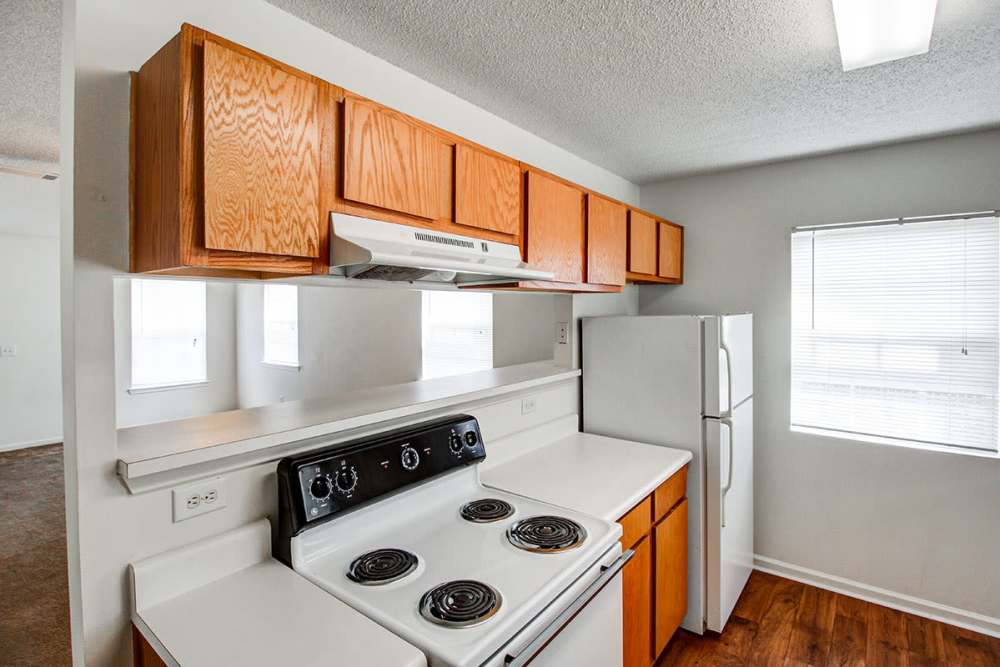 Bright kitchen with wood-style flooring, white appliances, and wooden cabinets at Valley View Gardens in Dunlap, Tennessee
