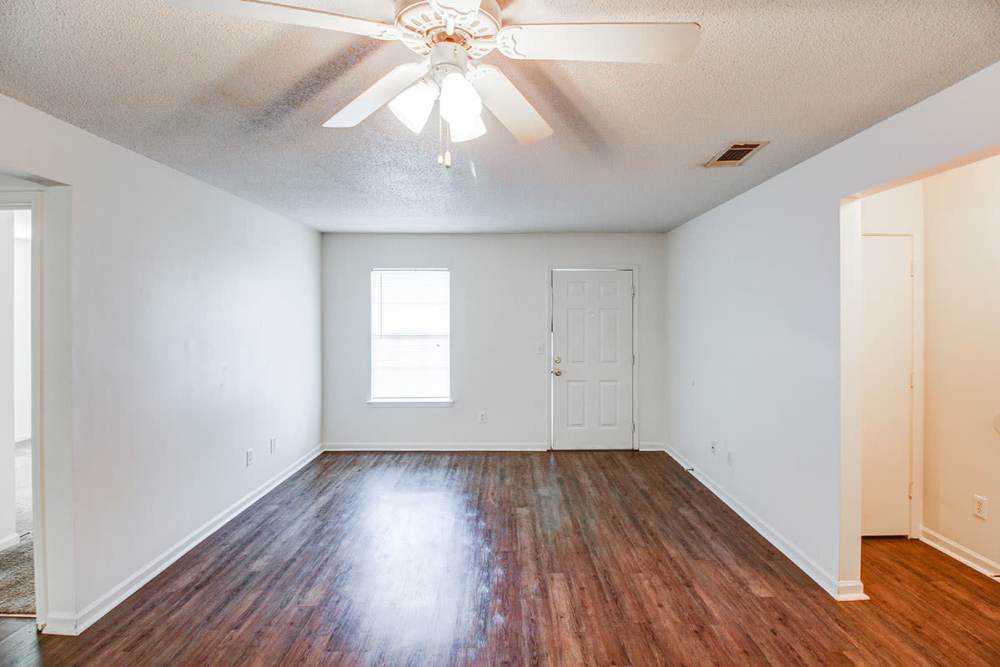Spacious living area with wood-style flooring and ceiling fan, natural light from window at Valley View Gardens in Dunlap, Tennessee