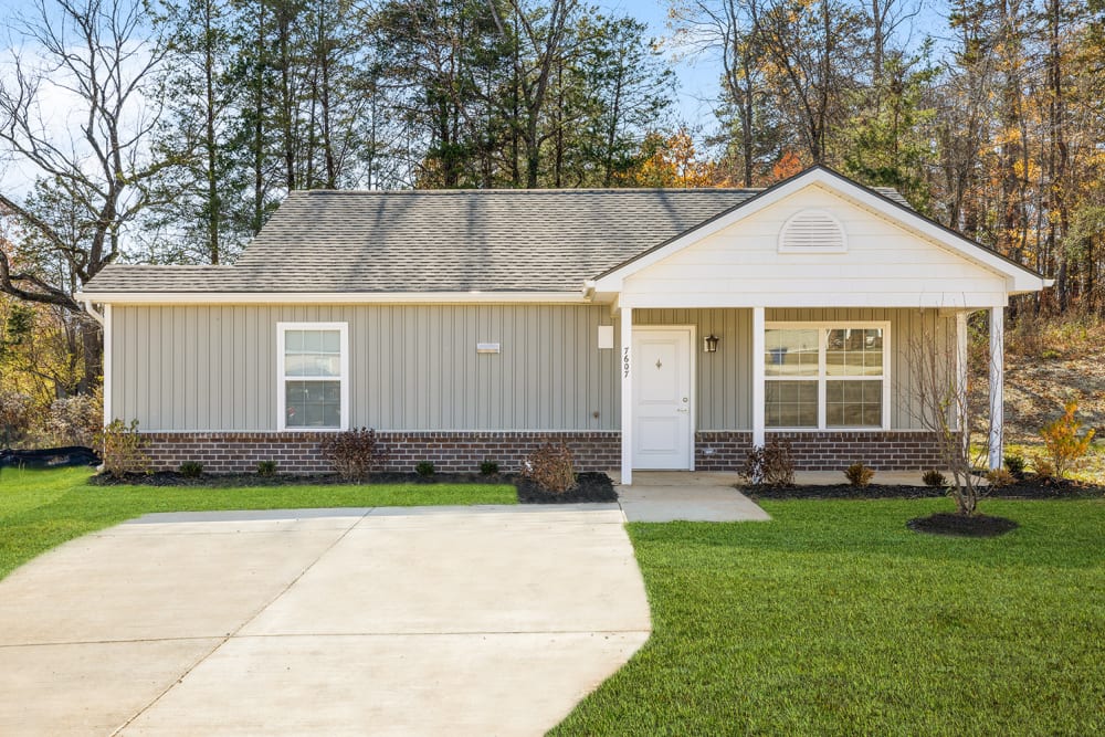 Single-story home with a landscaped yard and a welcoming front porch at Woodbury Crossing in Corryton, Tennessee