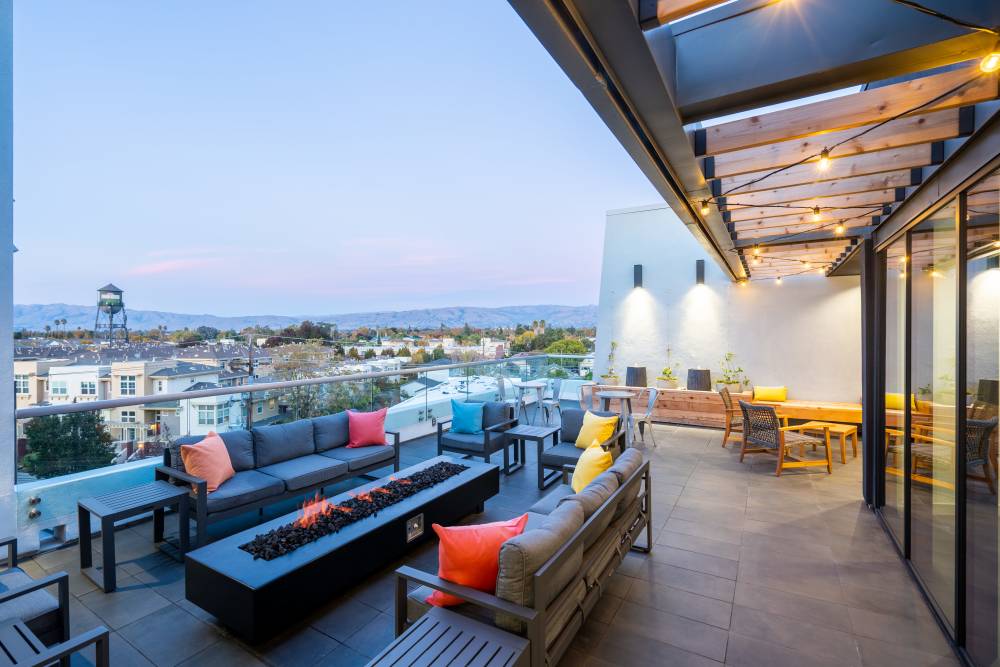 Rooftop patio with modern furniture, fire pit, and city views, perfect for entertaining at Exhibit at J Town in San Jose, California