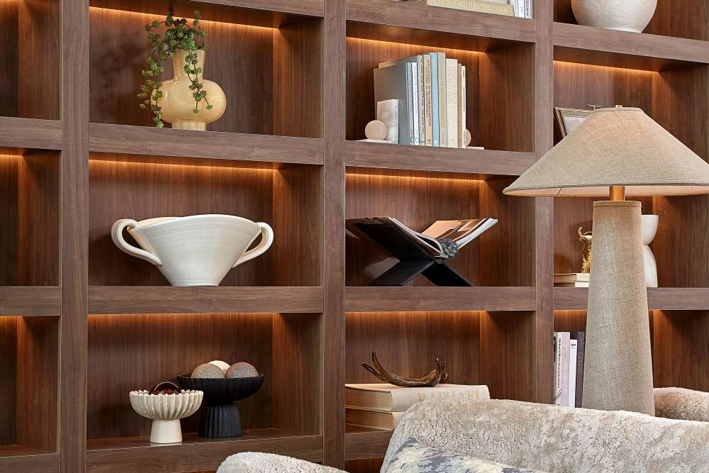 Close‑up of decorative shelving with books, pottery, and accent lighting at The Millwright in Cornelius, North Carolina
