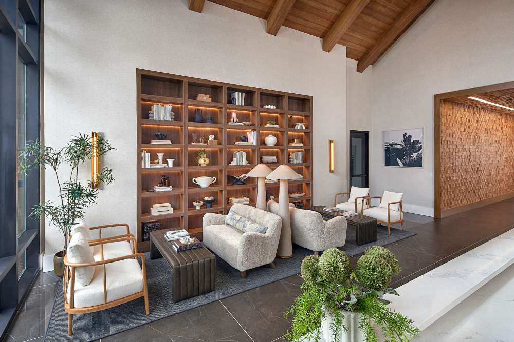 Stylish lobby lounge with built‑in bookshelves, seating, and warm lighting at The Millwright in Cornelius, North Carolina