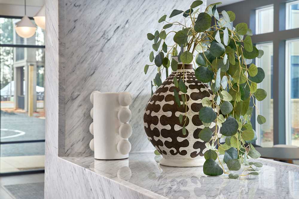 Decorative marble ledge with modern vases and cascading greenery at The Millwright in Cornelius, North Carolina