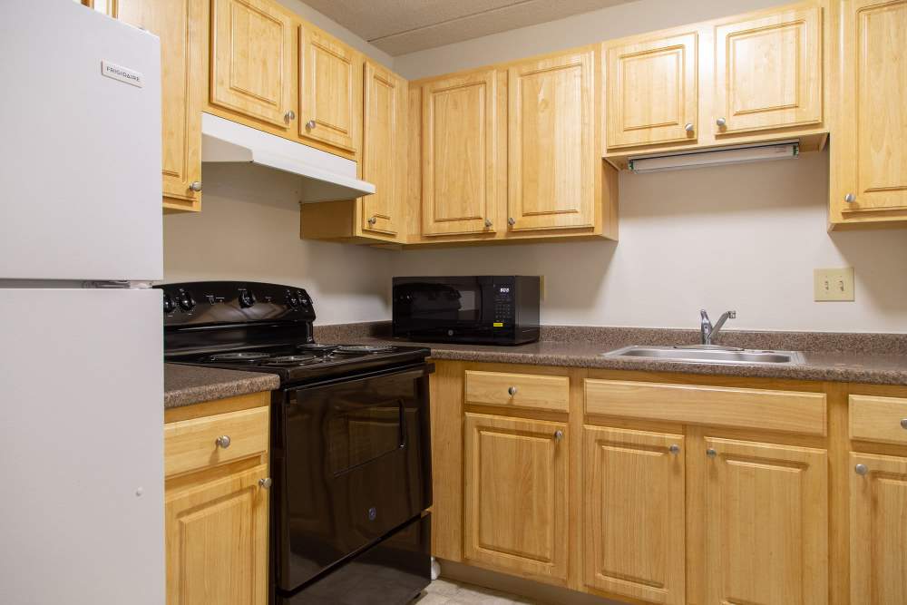 Kitchen with wooden cabinets at Rita Hall Apartments in Lawrence,Massachusetts
